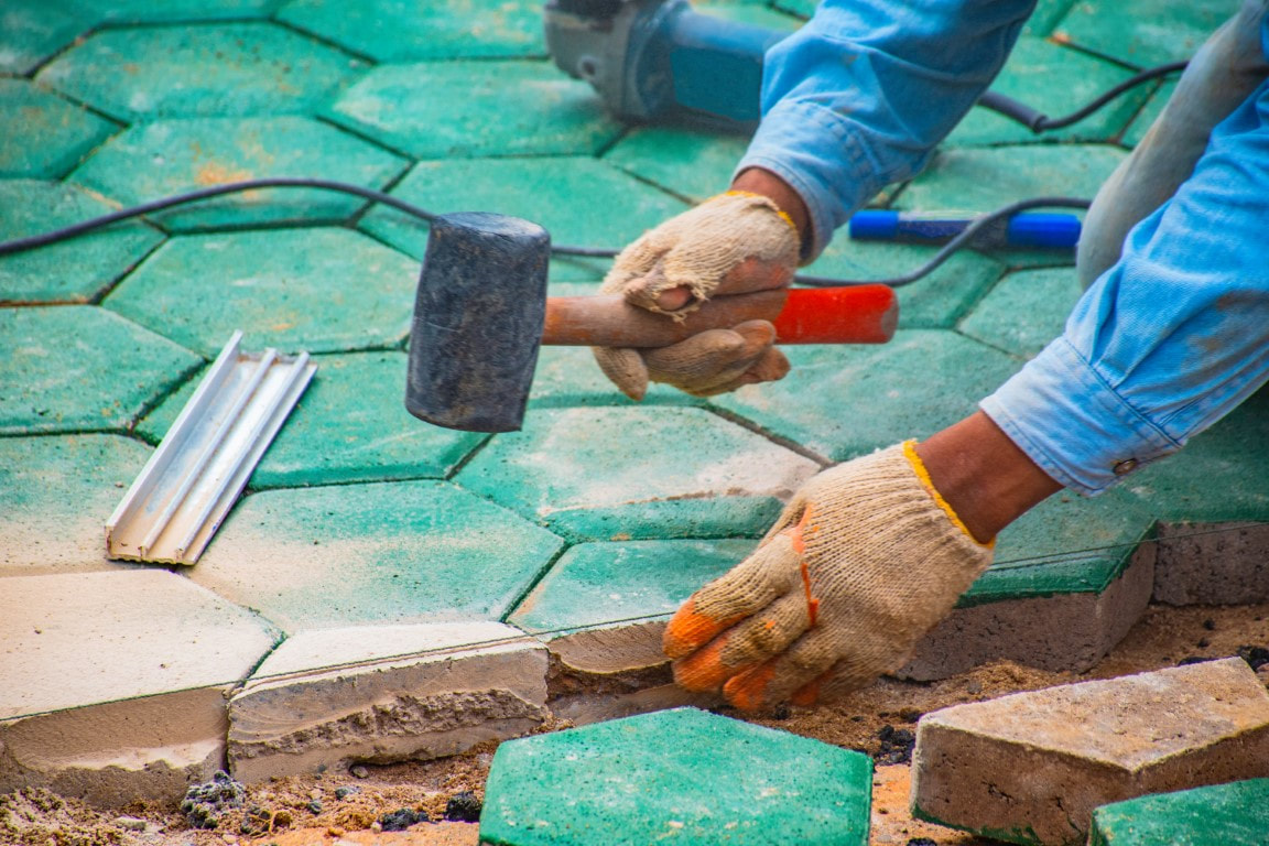 An image of a person applying paving stone in a paver walkway