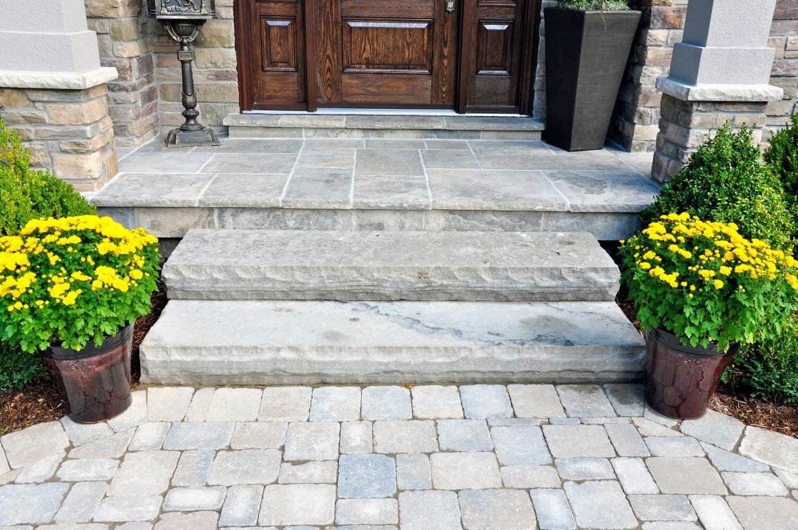 An image of a beautiful paver walkway in front of a house